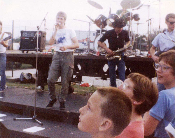 The Dream Factory at the Tamworth Rock Festival in August 1984. It shows left to right Lloyd Barnett, Tim Goode, Andy Codling and Mark Mortimer with drummer Steve Quilton perched above at the rear! Look at the age of the audience!